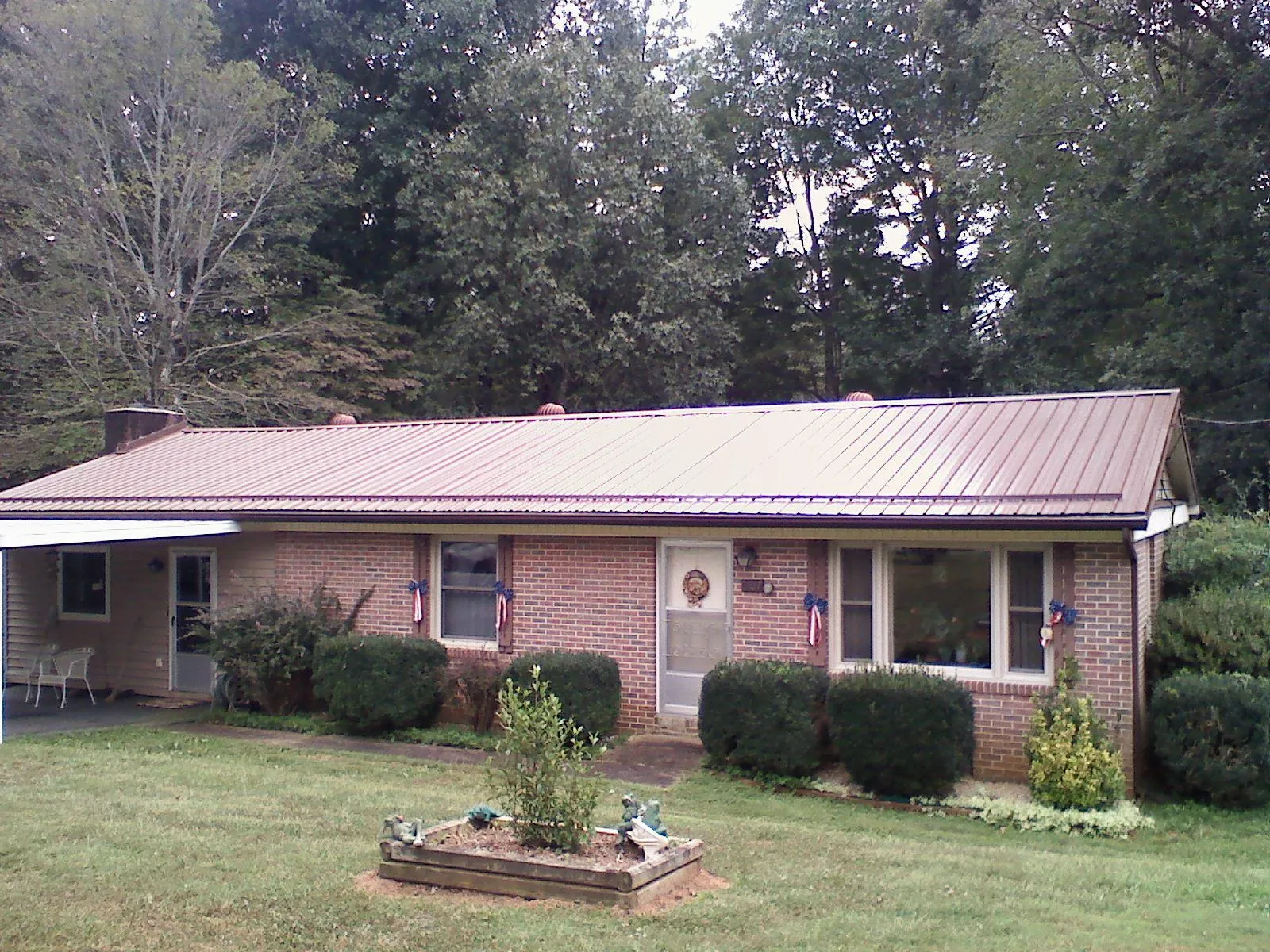 Bronze metal roof on a brick ranch home with a carport in Montrose