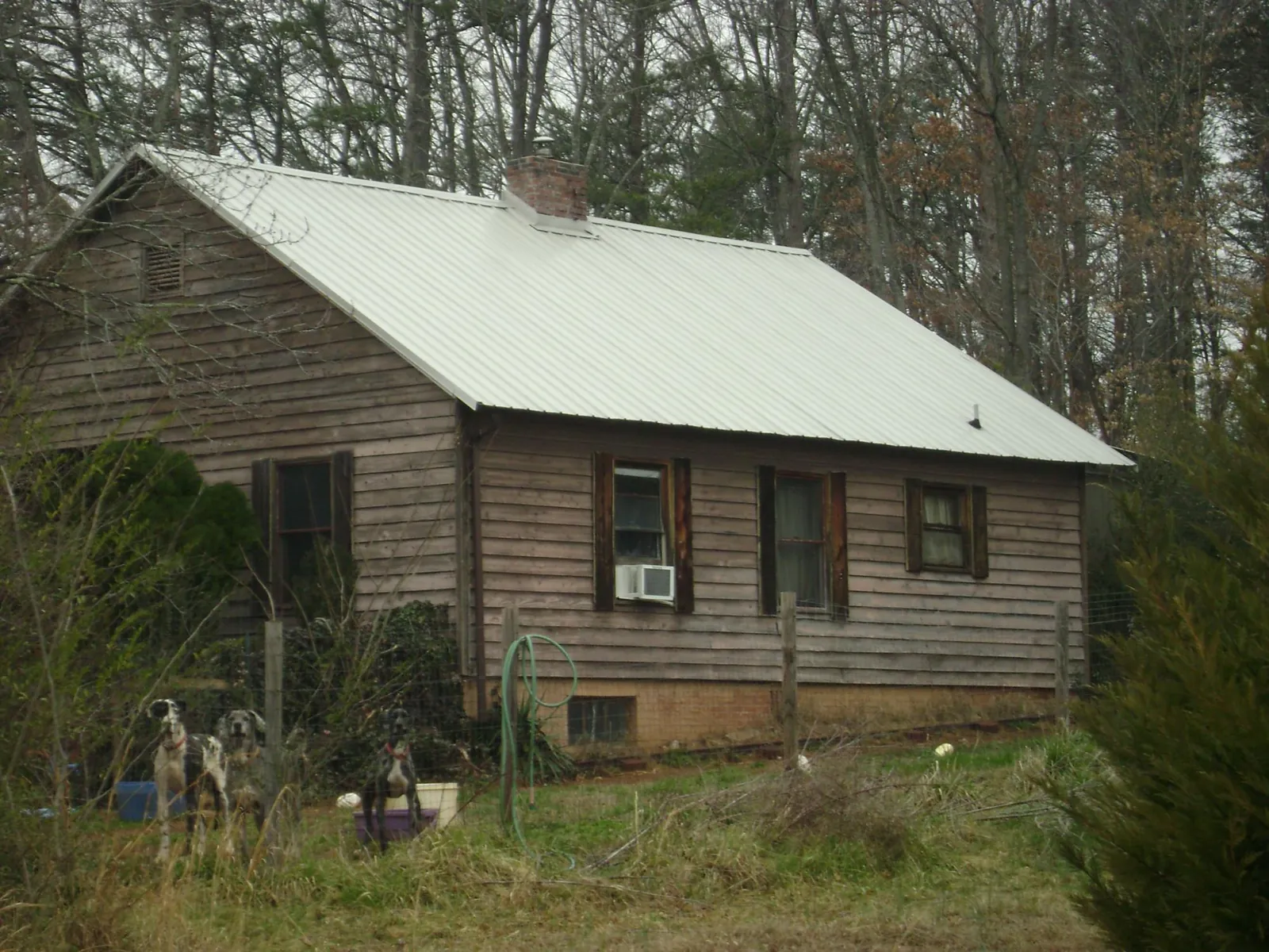 White metal roof on an old wood sided farmhouse, from a Metal Roof Installation job in Montrose